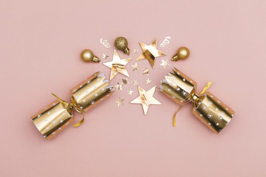 gold Christmas Crackers on pink background